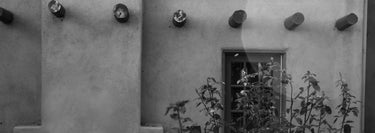 A black and white photograph of the back of the adobe-style CAC building at 1705 Five Points Rd SW.